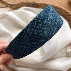 Dettaglio del cerchietto in tweed blu con design a fascia larga e tessuto intrecciato