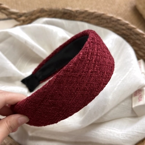 Dettaglio macro del cerchietto largo in tweed bordeaux con morbido rivestimento interno