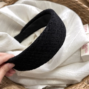 Dettaglio del cerchietto largo in tweed nero con fodera liscia e tessuto spesso in stile francese