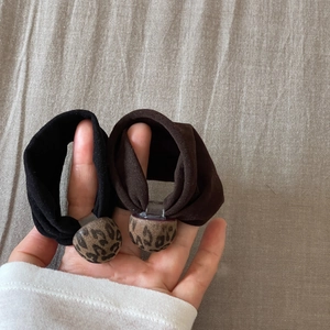 Close-up of black and dark coffee fabric scrunchies with leopard print round ornaments