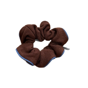 Chic brown knit scrunchie hair tie with contrast light blue trim on a white background