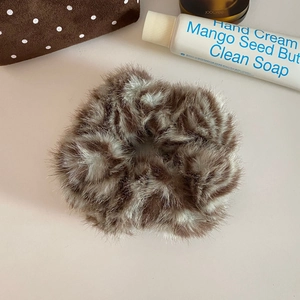 Detailed view of a soft faux fur leopard print scrunchie with plush texture and elastic band