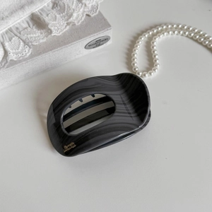 Detailed shot of large grey marble claw clip with gold Barrette La France lettering