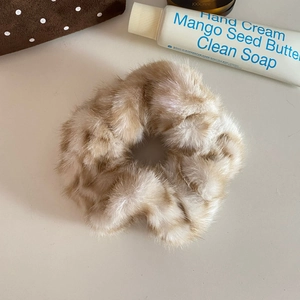 Detailed view of plush leopard print faux fur scrunchie with soft fluffy texture and high elasticity