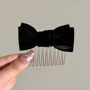 Detail of handmade black velvet bow hair comb with multi-tooth metal clip for women