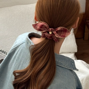 Chouchou vintage à carreaux rouges avec pendentif doré sur une coiffure en queue de cheval