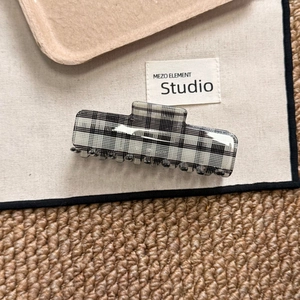 Macro shot of large rectangular hair claw clip with classic black and white checkered pattern