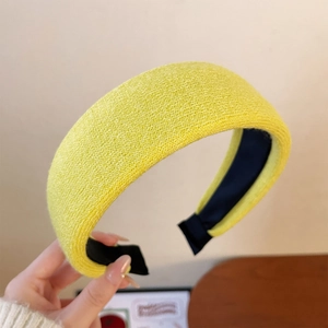 Detail view of yellow knitted wide headband with thick texture and anti-slip lining