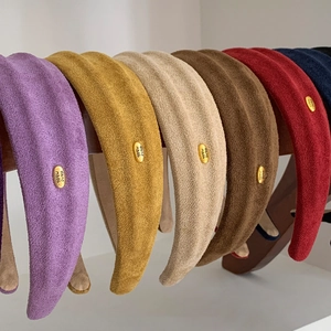 Faux suede sponge headbands in various colors with handmade gold metal tags