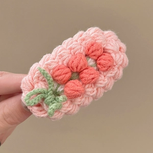 Détail de la pince à cheveux faite main au crochet avec motif floral rose et orange