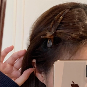 Elegant tortoiseshell pattern acetate hair clip worn on side swept dark brown hair