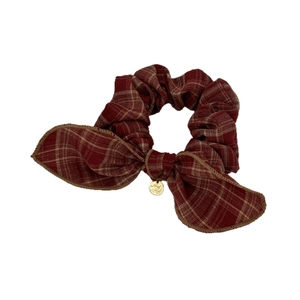 Chouchou à nœud à carreaux rouges classiques avec pendentif doré sur fond blanc uni
