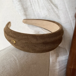Detail view of brown faux suede wide headband with gold Handmade metal plaque