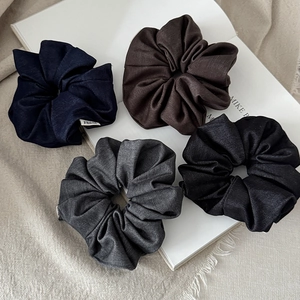 Set of four large fabric scrunchies in navy, brown, grey, and black colors for hair