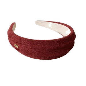 Deep red faux suede padded headband with gold metal logo and smooth inner lining