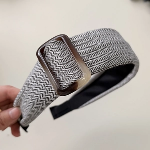 Close-up of elegant herringbone fabric headband with amber resin buckle detail