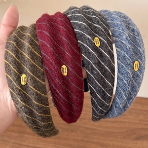 Set of four knitted striped headbands in coffee, red, grey and blue with gold labels
