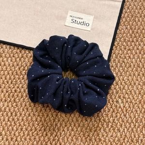 Detail of navy blue polka dot hair scrunchie with soft fabric texture and vintage design
