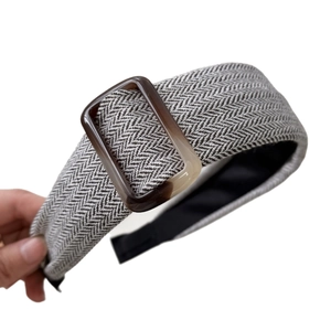 Black and white herringbone headband with amber resin buckle on white background