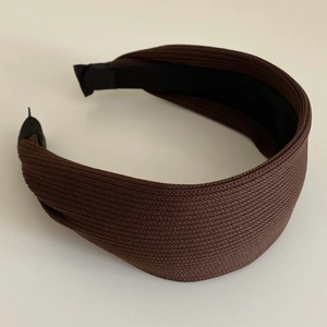 Close-up of the fine ribbed knitting texture on a wide dark brown headband for women