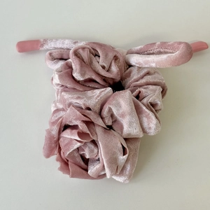 Détail de chouchou fleur rose en velours avec finitions scellées en caoutchouc souple