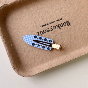 Blue gingham check hair clip with sparkling rhinestones in a brown tray