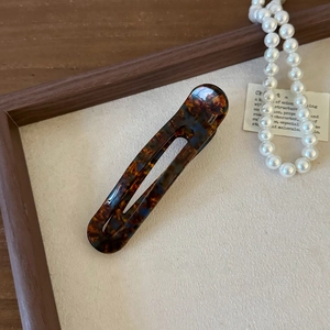 Detailed macro view of a tortoiseshell acetate hair clip with FRANCE Handmade engraving