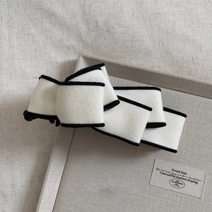 Detail of the elegant black and white bow hair clip with plush textured velvet finish