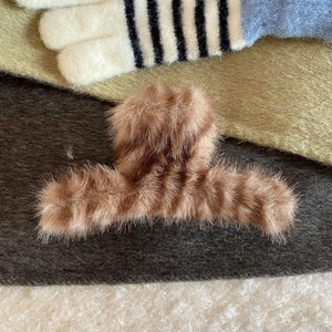 Detail of plush brown striped claw clip with soft faux fur texture for thick hair