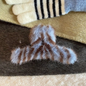 Detailed view of large plush hair claw clip with brown and light blue stripes