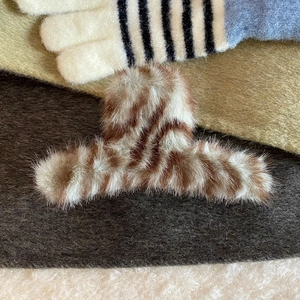 Macro shot of fluffy brown striped faux fur hair claw clip with soft texture details