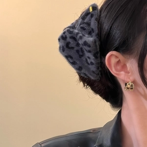 Pince à cheveux chic en fausse fourrure léopard présentée de profil sur un mannequin