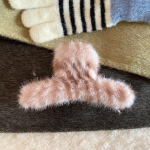 Close-up of a pink plush faux fur hair claw clip for autumn hair styling and accessories