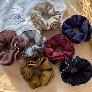 7-piece knit scrunchies set with wavy edges in earthy colors like brown, beige, and navy