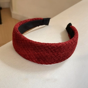 Détail macro du tissu tweed bordeaux sur le serre-tête rembourré avec doublure antidérapante