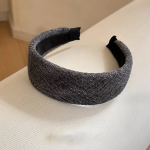Détail d'un serre-tête en tweed gris avec texture tissée épaisse et doublure