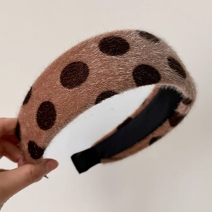 Close-up of plush brown polka dot headband with soft faux mink fur texture and black inner lining