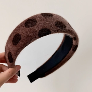Detail of plush brown polka dot headband showing thick velvet texture and non-slip lining