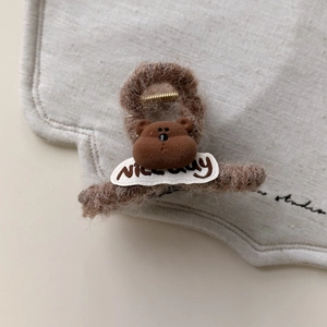 Detalle de la pinza para el pelo de felpa marrón con bordado de oso y texto Nice Day