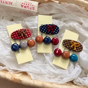 Polka dot hair clip set with velvet bows and colorful beads on yellow display card