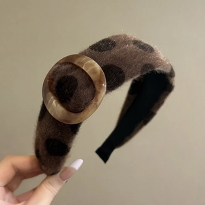 Close-up of brown plush headband featuring black polka dots and marble resin buckle detail