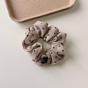 Detail of knitted cream polka dot hair scrunchie with Made in Korea woven label
