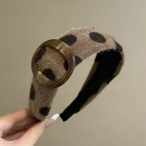 Close-up of leopard print plush headband featuring a translucent amber resin buckle detail