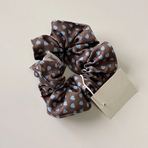 Dettaglio di un elastico marrone con cuori blu e etichetta del marchio Sweety girl
