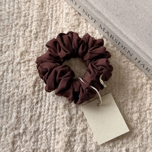 Vue détaillée d'un chouchou en satin marron foncé avec bordure dentelle et étiquette