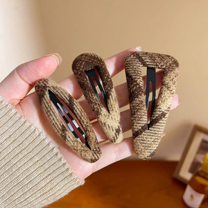 Brown plaid fabric hair clips set for women showing three shapes in a hand display