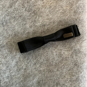 Barrette à cheveux élégante en satin noir avec plaque vintage sur fond en peluche