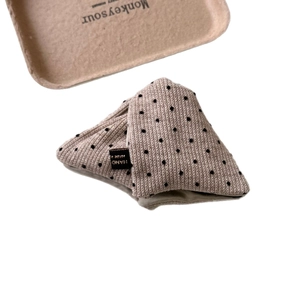 Minimalist apricot knit hair claw with black polka dots and handmade fabric label