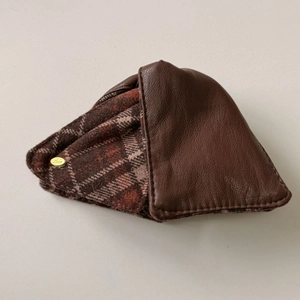 Macro shot of faux leather and plaid fabric patchwork detail on the triangular hair clip