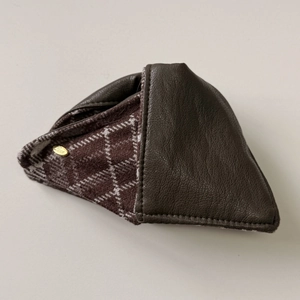 Detail of leather and plaid fabric hair claw clip with a gold Love metal logo
